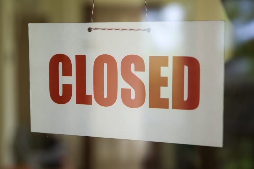 Closed sign board hanging on door of cafe